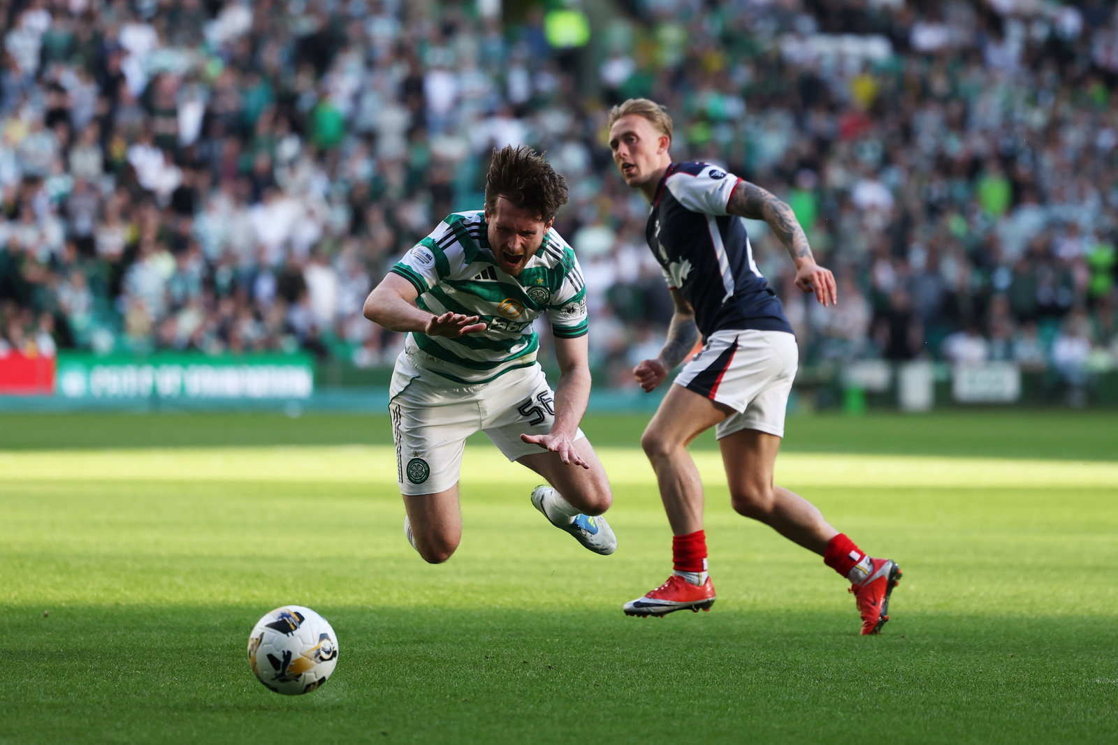 Anthony Ralston of Celtic is challenged by Calvin Miller